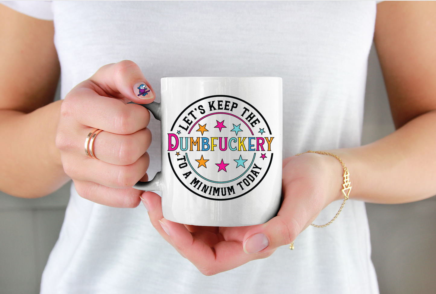 Person holding a mug with colorful text design
