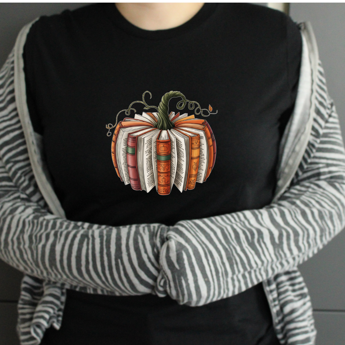 Person wearing a black shirt with a pumpkin design