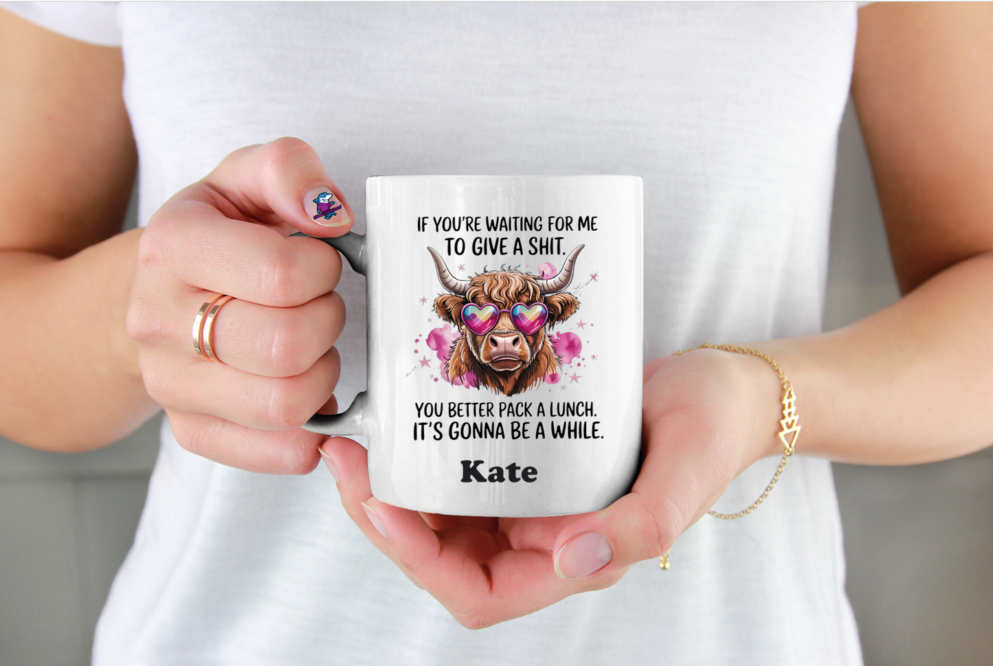 Person holding a mug with a humorous design and text.