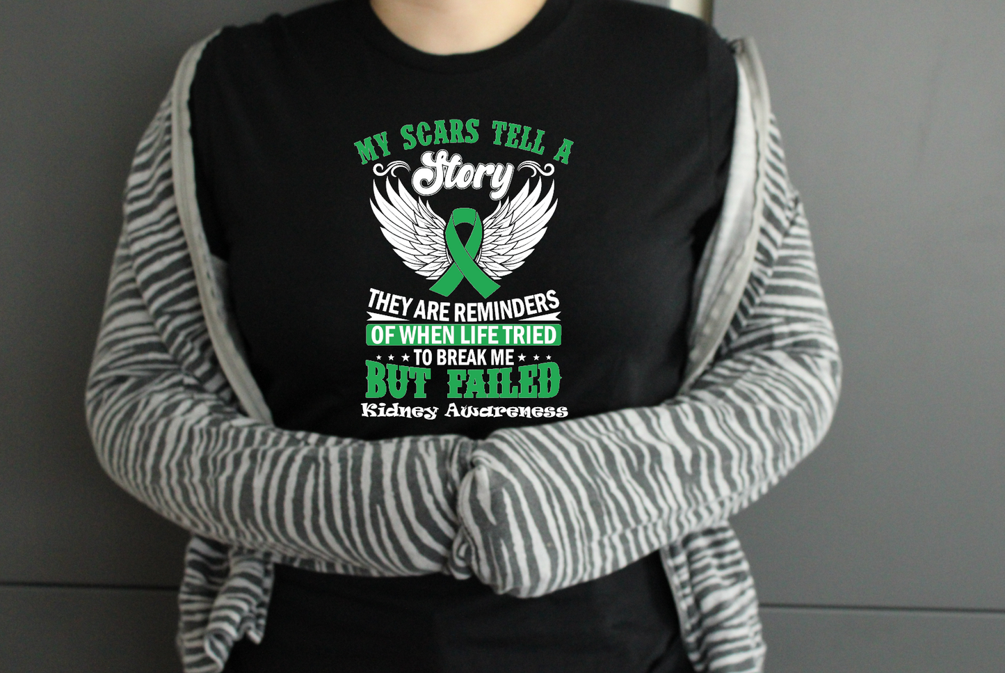 Person wearing a black shirt with kidney awareness message and green ribbon