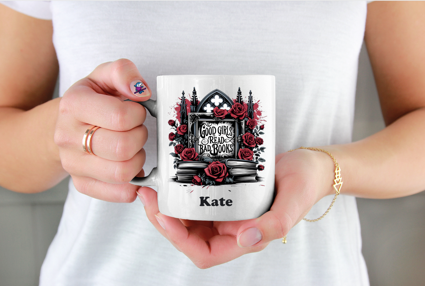 Person holding a mug with a design of roses and a cathedral, and the name 'Kate' on it.