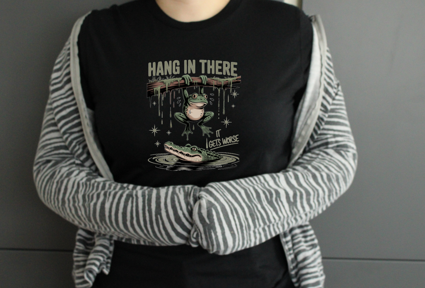 Person wearing a black tshirt with a graphic design and text.