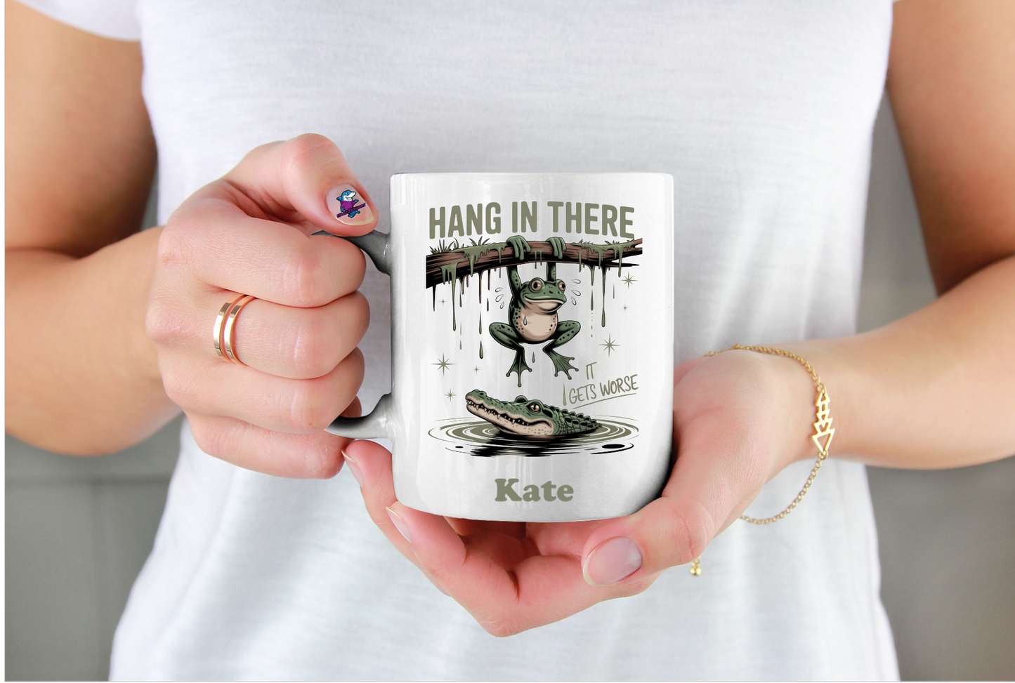 Person holding a mug with a motivational design and name 'Kate'.