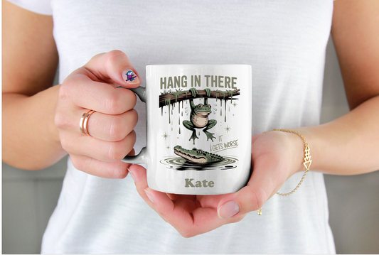 Person holding a mug with a motivational design and name 'Kate'.