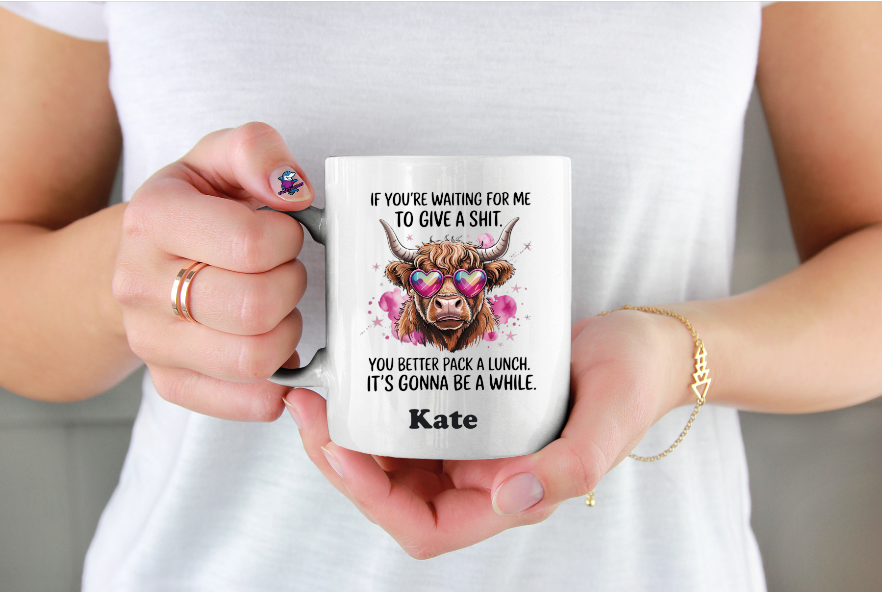 Person holding a mug with a humorous design and text.