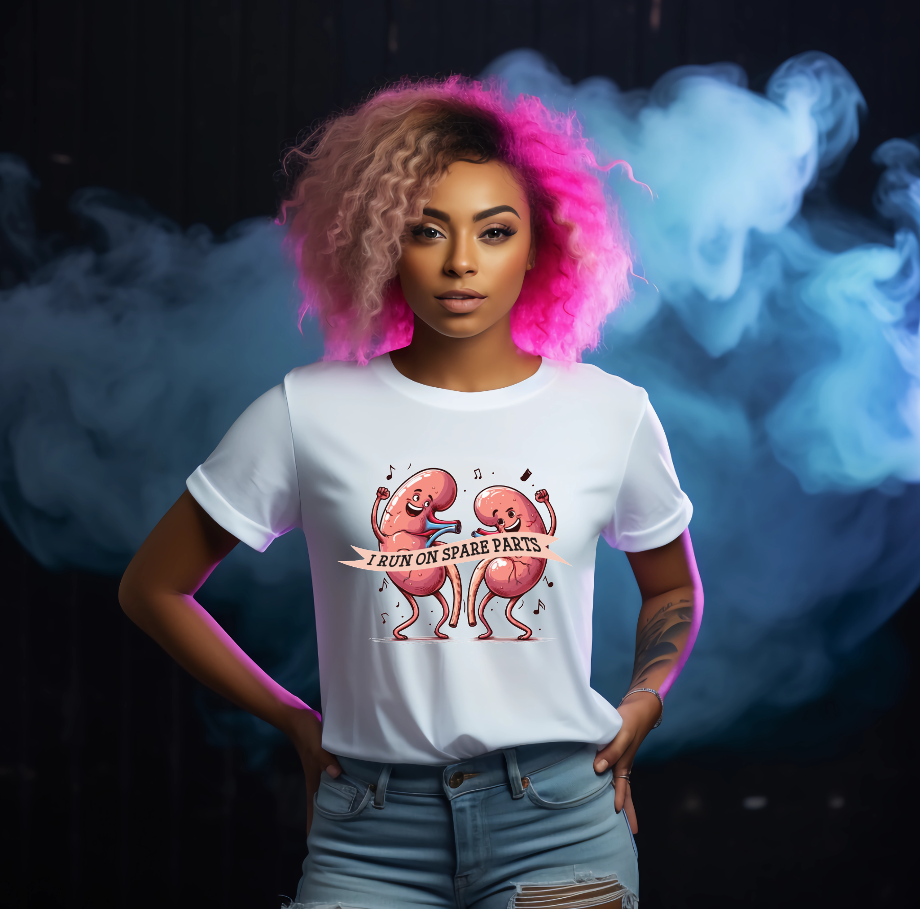 Person wearing a white t-shirt with a graphic design and text saying i run on spare parts for kidney transplant awareness, standing against a dark background with smoke effects.