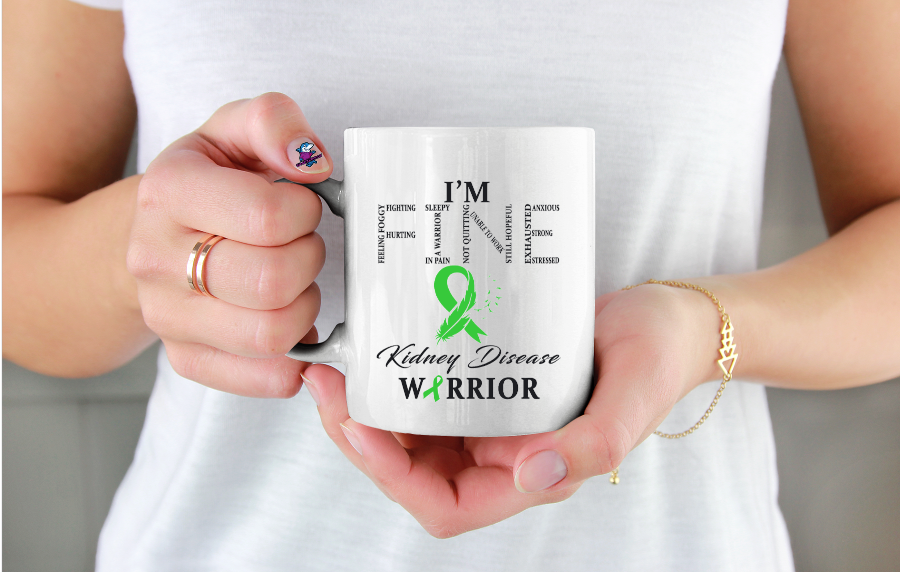 Person holding a mug with 'I'm a Kidney Disease Warrior' text and green ribbon design.