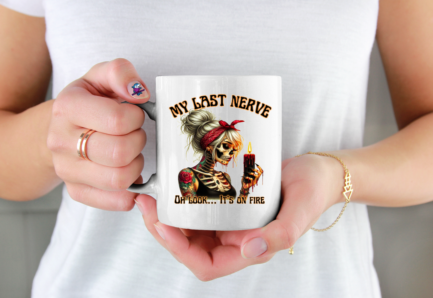 Person holding a mug with a skeleton design and text.