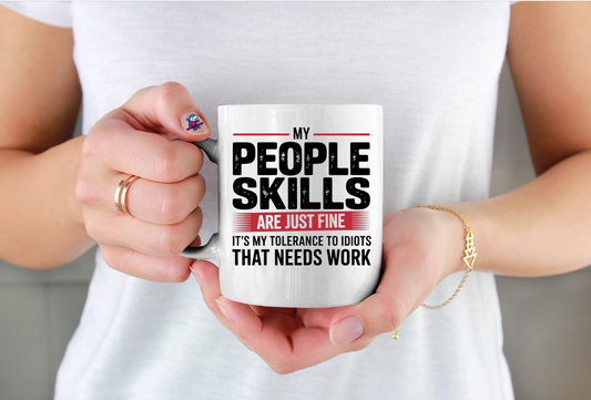 Person holding a mug with humorous text about people skills.