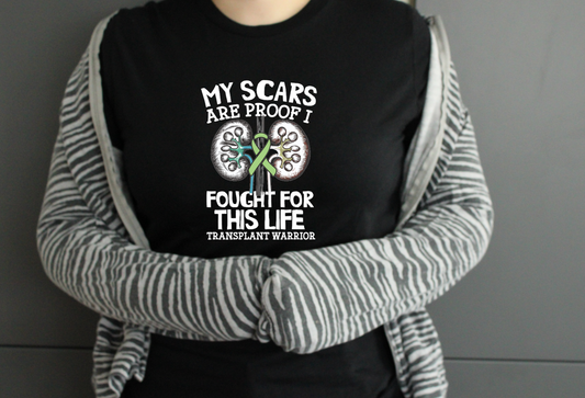 Person wearing a black t-shirt with a transplant warrior message and striped sleeves.