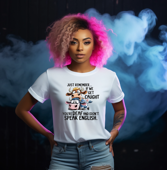 Person wearing a white t-shirt with a graphic and text, standing against a dark background with smoke effects.