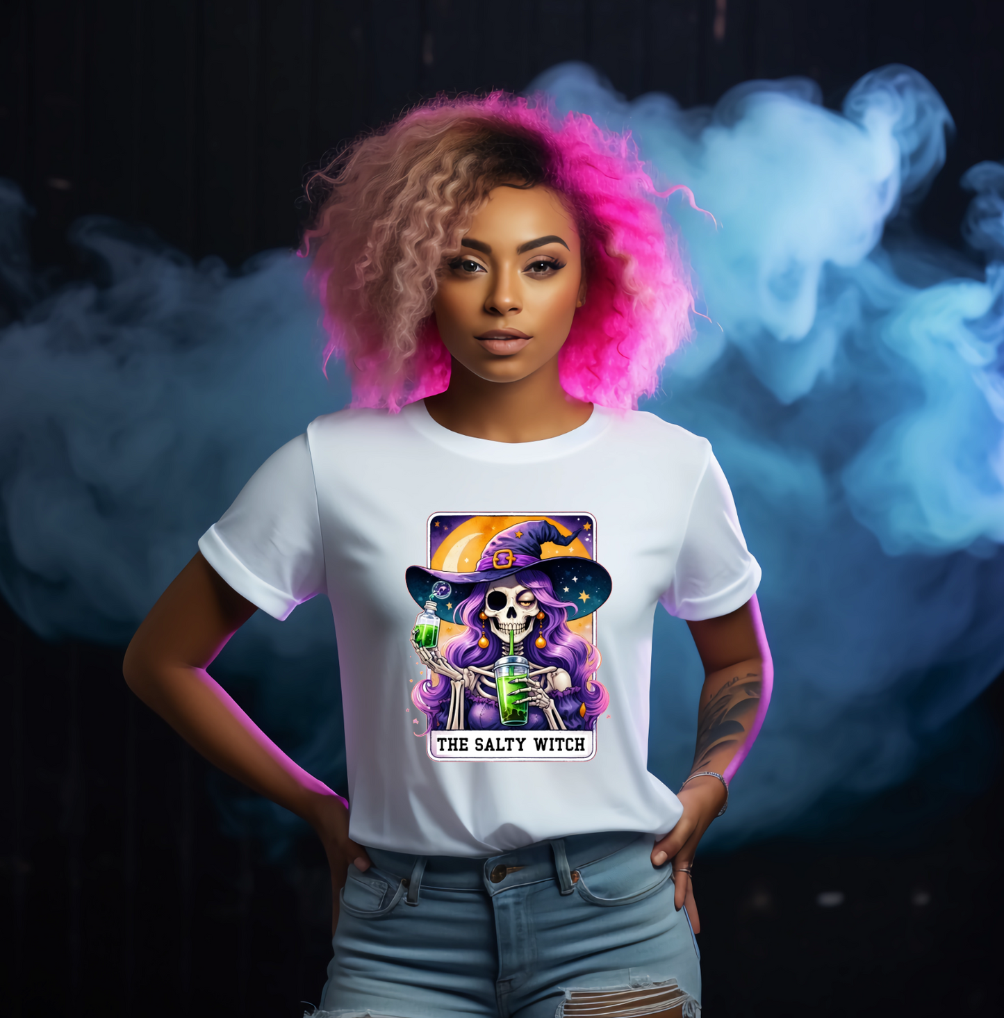 Person wearing a white t-shirt with a colourful graphic design against a dark background with smoke effects with tarot cart the salty witch