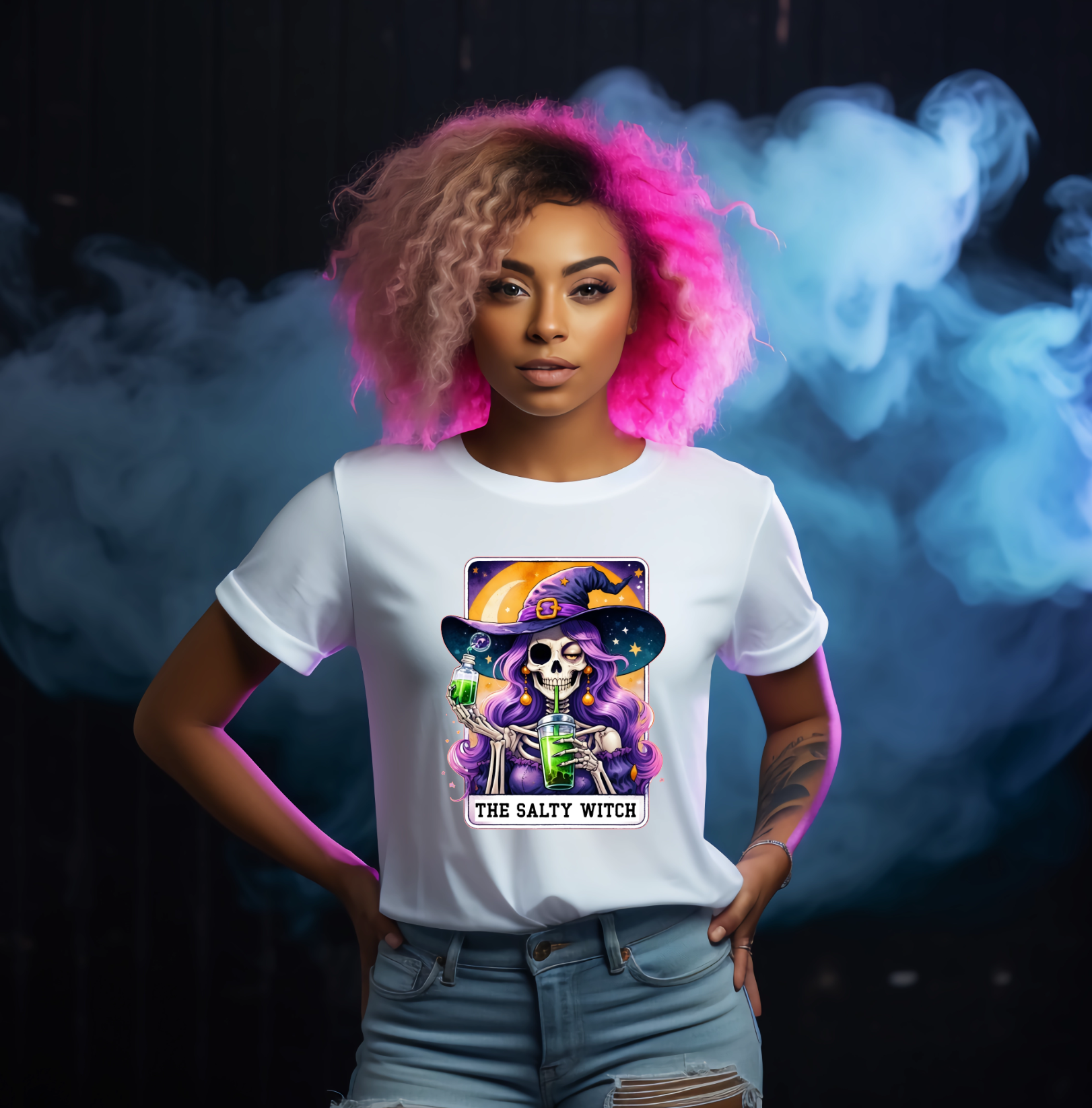 Person wearing a white t-shirt with a colourful graphic design against a dark background with smoke effects with tarot cart the salty witch