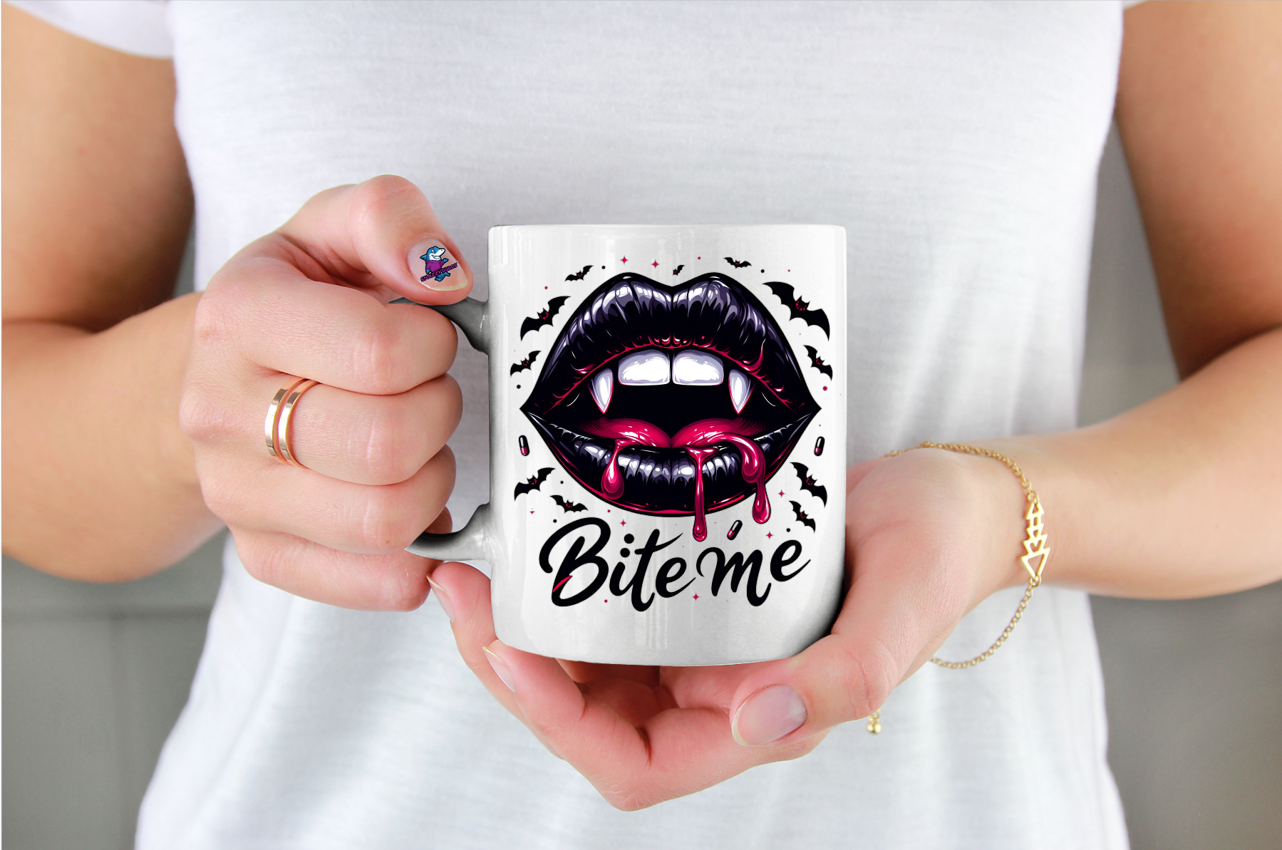 Person holding a mug with vampire lips design and 'Bite me' text