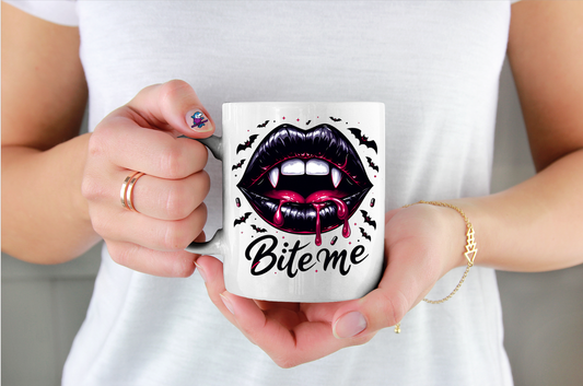 Person holding a mug with vampire lips design and 'Bite me' text