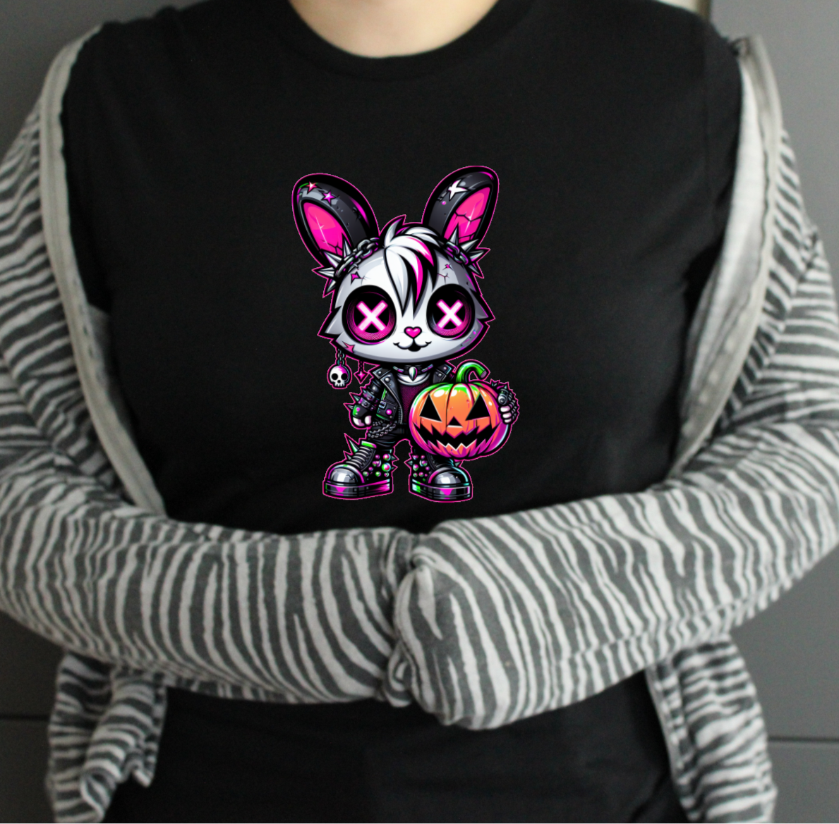 Person wearing a black tshirt with a colorful cartoon character design, standing against a neutral background.