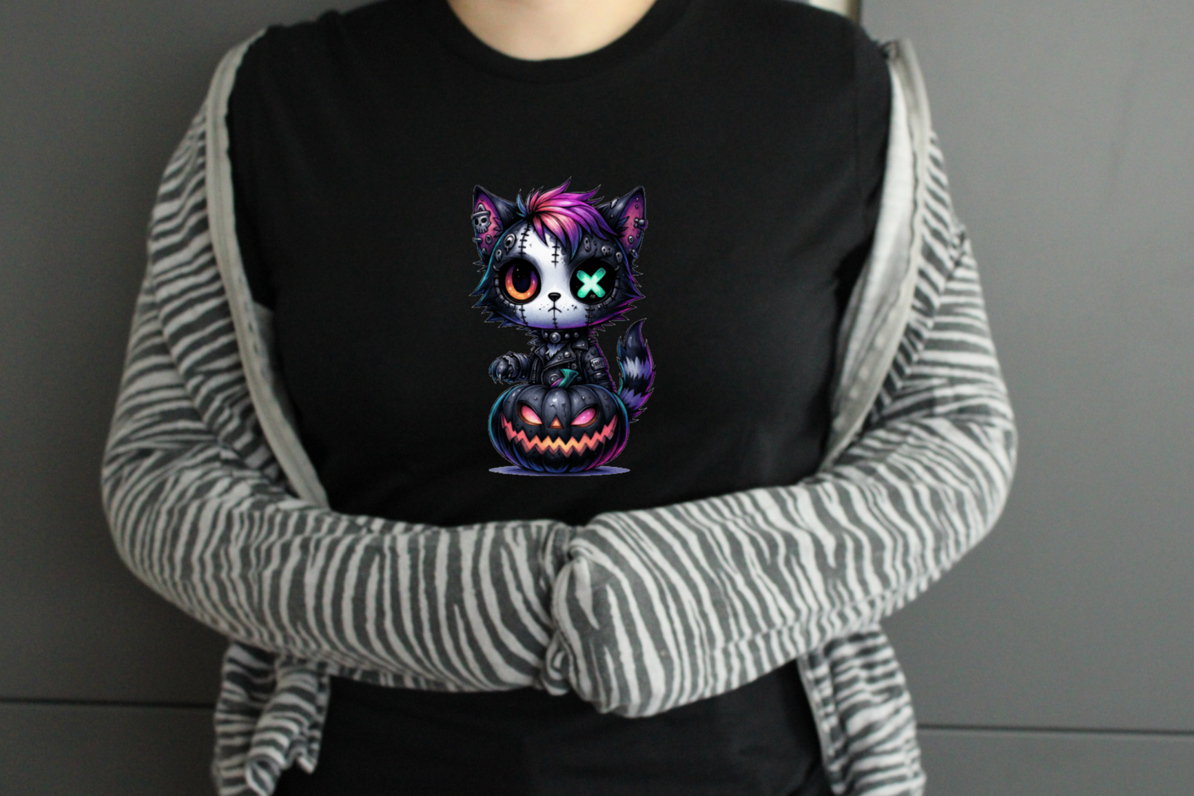 Person wearing a black shirt with a colorful cat design, striped sleeves.