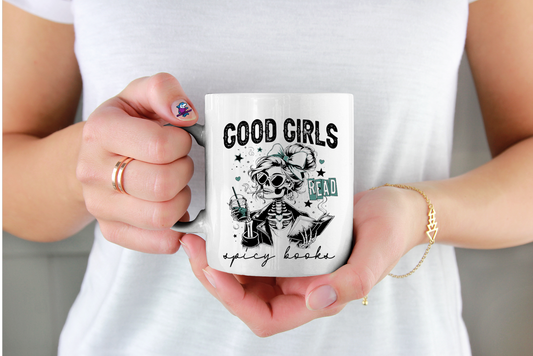 Person holding a mug with a graphic design and text good girls read spicy books