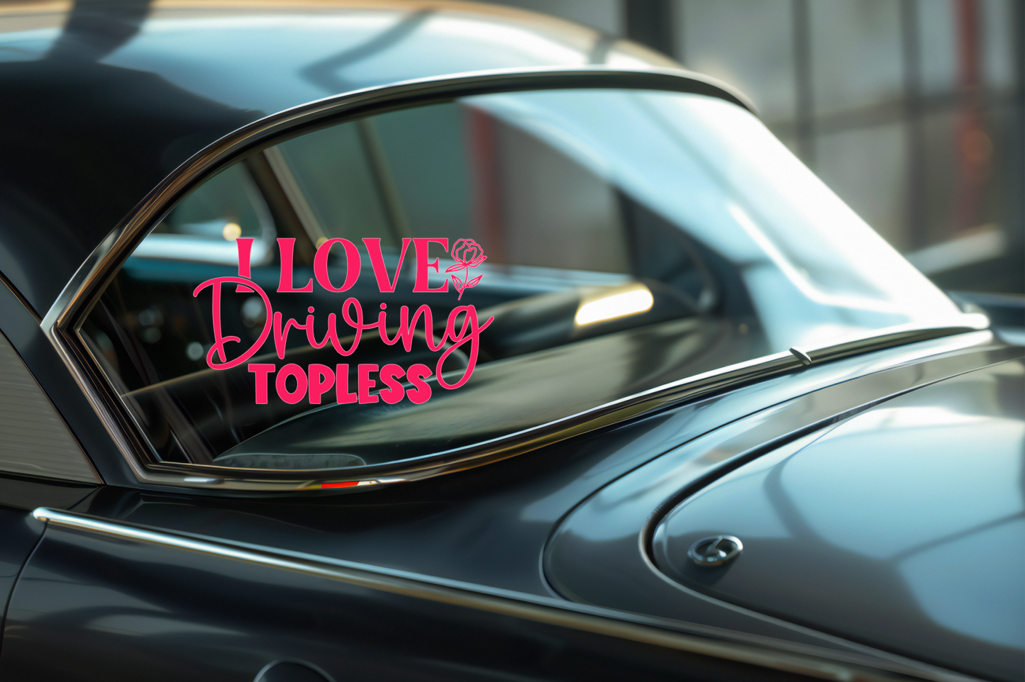 Car window with a decal reading 'I LOVE Driving TOPLESS' on a reflective surface.