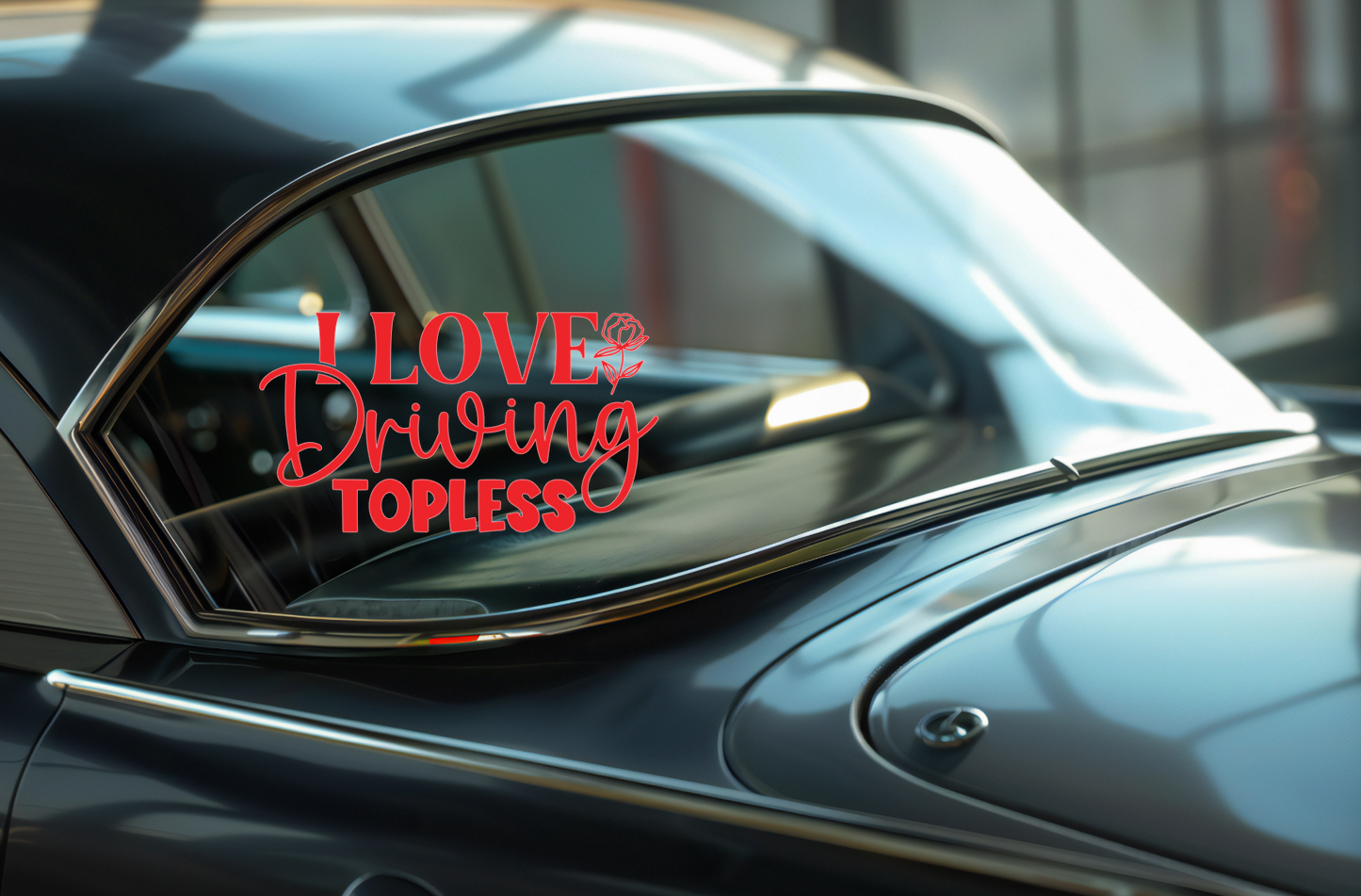 Car window with a decal reading 'I LOVE Driving TOPLESS' on a reflective surface.