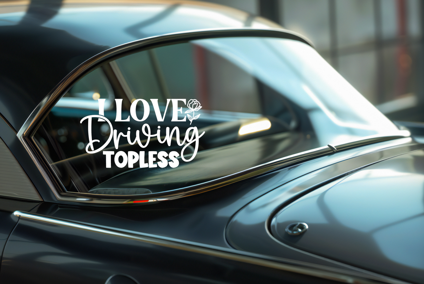 Car window with a decal reading 'I Love Driving Topless' on a blurred indoor background